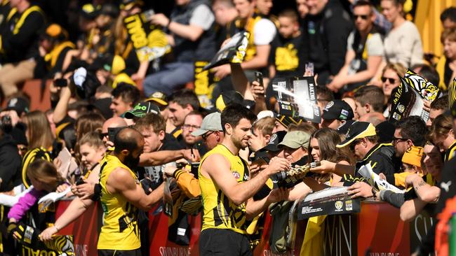 Bachar Houli and Trent Cotchin sign autographs at training.