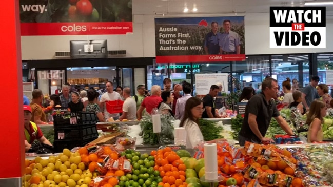 Shoppers line up at supermarket as COVID chaos sets in