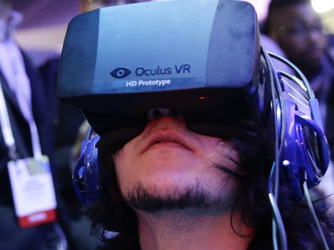 FILE - In this Jan. 7, 2014 file photo, show attendees play a video game wearing Oculus Rift virtual reality headsets at the Intel booth at the International Consumer Electronics Show(CES), in Las Vegas. Facebook said Tuesday, March 25, 2014, it has agreed to buy Oculus for $2 billion, betting that its virtual reality may be a new way for people to communicate, learn or be entertained. (AP Photo/Jae C. Hong, File)