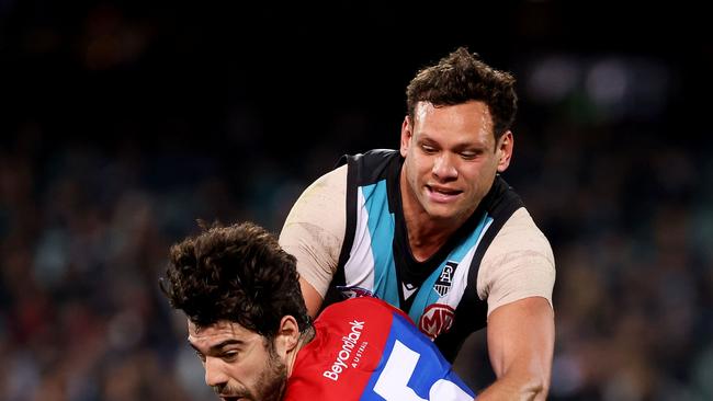 ADELAIDE, AUSTRALIA – JULY 08: Steven Motlop of the Power tackles Christian Petracca of the Demons during the 2021 AFL Round 17 match between the Port Adelaide Power and the Melbourne Demons at Adelaide Oval on July 8, 2021 in Adelaide, Australia. (Photo by James Elsby/AFL Photos via Getty Images)