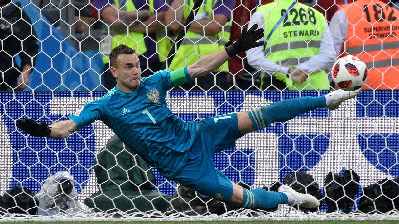 Russia's goalkeeper Igor Akinfeev stops a shot by Spain's forward Iago Aspas during the penalty shootout.