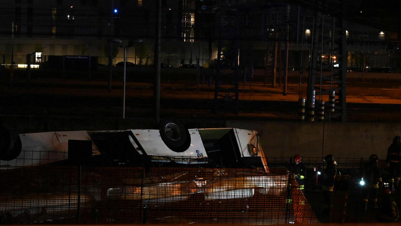 The bus caught fire after veering off a bridge connecting the Mestre and Marghera districts and hitting power lines. Picture: Marco Sabadin / AFP