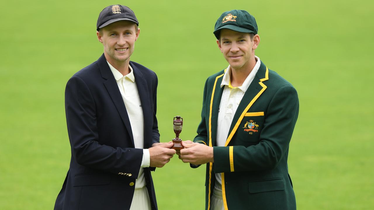 Joe Root (L) and Tim Paine pose for photos while holding the urn.