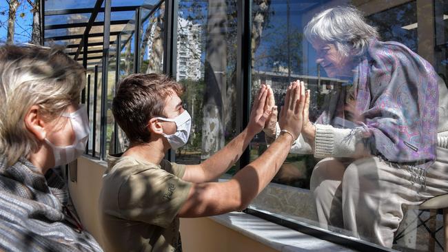 Brazilian Alexandre Schleier speaks with his 81-year-old grandmother Olivia Schleier through a window at the Premier Hospital, in Sao Paulo, Brazil. Picture: AFP