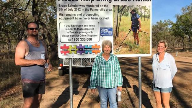 Murder victim Bruce Schuler's wife Fiona Splitt (centre), along with son Bruce Jnr and sister Tracey Holland alongside one of the four signs erected in Cape York calling for information about the whereabouts of his remains.
