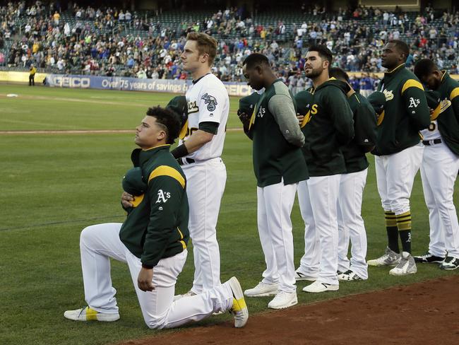 Oakland Athletics catcher Bruce Maxwell kneels during the National Anthem.