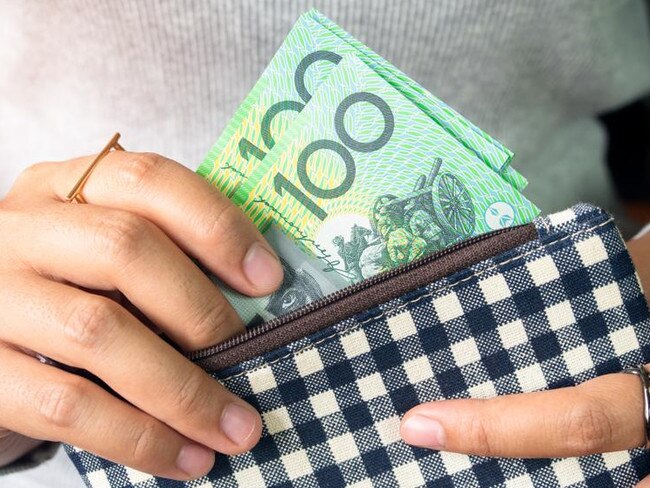 Woman put dollar australia money into wallet.