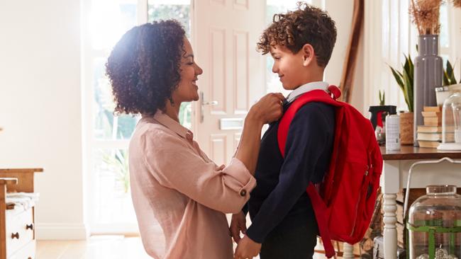 Single Mother At Home Getting Son Wearing Uniform Ready For First Day Of School