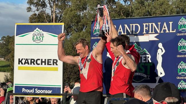 Healesville co-captains Daniel Plozza and Nick Mende hold the cup aloft with coach Ryan Webster.