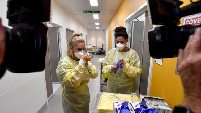 RAH registered nurses Chenae Spencer-Attard and Stephanie Kipirtoglou get kitted up at the hospital’s coronavirus testing clinic. Picture: Sam Wundke