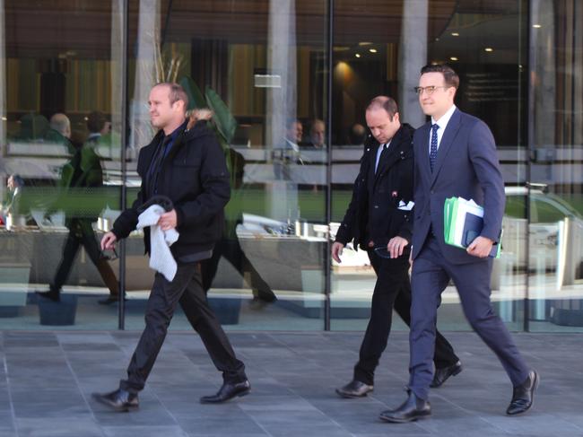 The twin brothers (left) leave ACT Magisrates Court with their lawyer Tom Taylor (right).