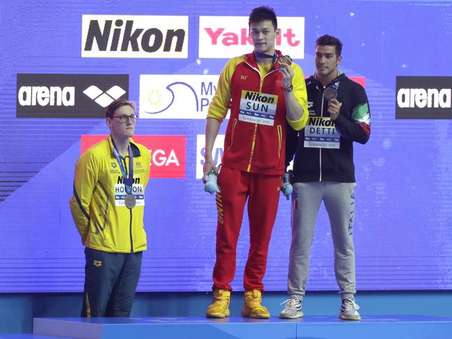 China's Sun Yang, centre, holds up his gold medal as silver medalist Australia's Mack Horton, left, stands away from the podium with bronze medalist Italy's Gabriele Detti right, after the men's 400m freestyle final at the World Swimming Championships in Gwangju, South Korea, Sunday, July 21, 2019. (AP Photo/Mark Schiefelbein)