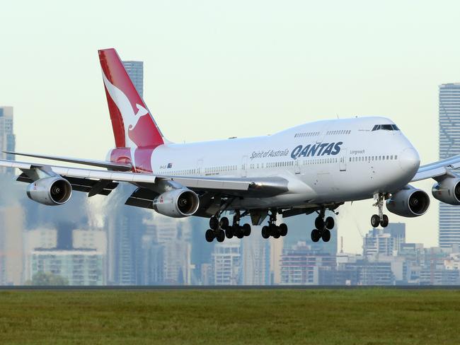 QANTAS plane landing at Brisbane Airport with Brisbane City buildings in background. Photographer: Liam Kidston.