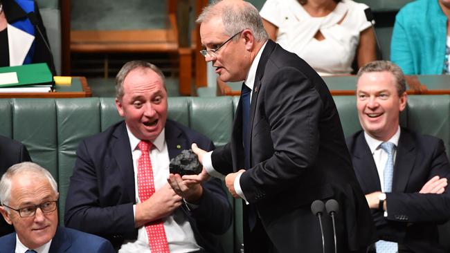 Treasurer Scott Morrison hands Deputy Prime Minister Barnaby Joyce a lump of coal during Question Time. (Pic: AAP Image/Mick Tsikas)