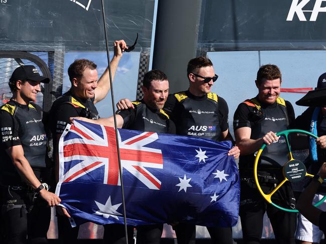 Australia Team Driver Tom Slingsby (R) celebrates victory with teammates at the end of final race of the Sail Grand Prix event on Sydney Harbour on February 25, 2024. (Photo by DAVID GRAY / AFP) / -- IMAGE RESTRICTED TO EDITORIAL USE - STRICTLY NO COMMERCIAL USE --