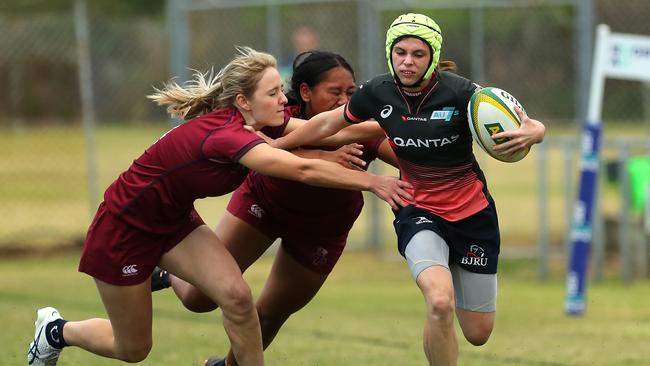 Abbi Spooner of the Barbarians fends off against Queensland.