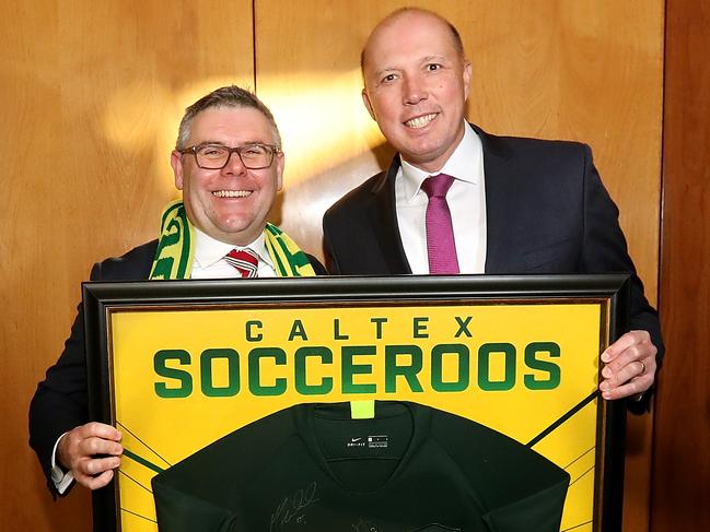 Labor Senator Murray Watt and Liberal MP Peter Dutton present Dom Calabria with framed Socceroos and Matildas jerseys on behalf of FFA to be hung in Aussies Cafe at Parliament House in Canberra. Picture Kym Smith