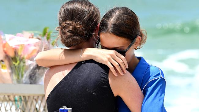 Two women hug as they visit the beach. Picture: NewsWire / John Gass