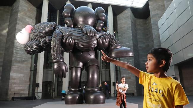 Krish, 6, gets up close and personal with a KAWS sculpture at National Gallery of Victoria. Picture: Alex Coppel.