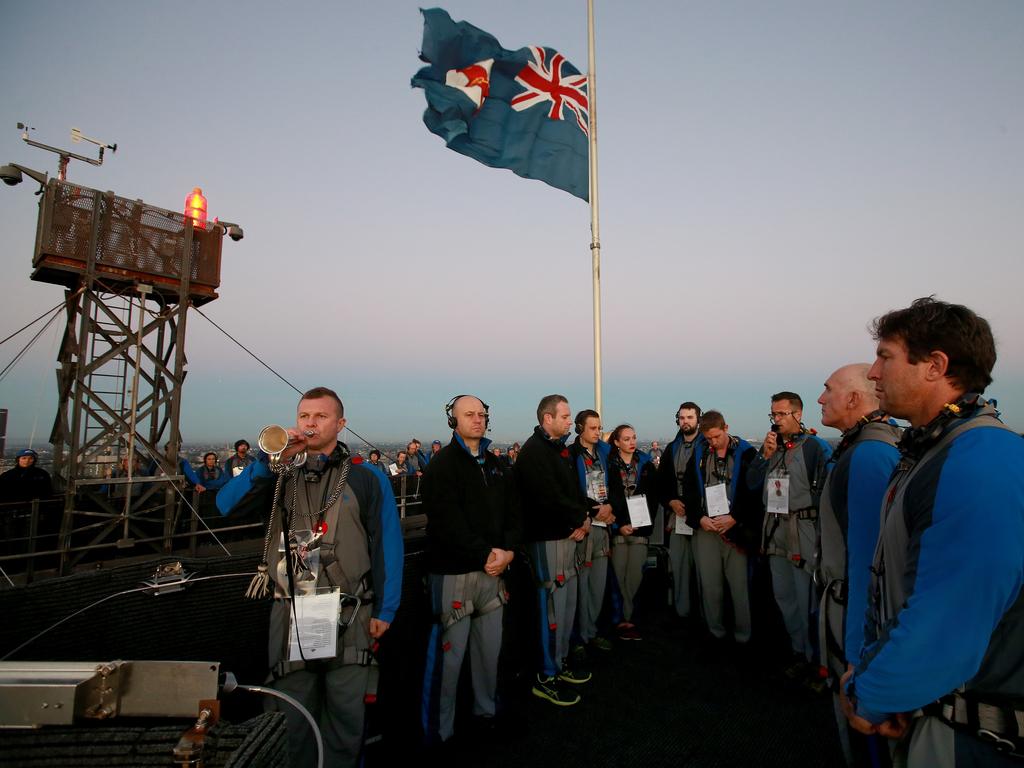 A dawn service was held on the summit of the Sydney Harbour Bridge to commemorate ANZAC Day. Bugler and Leading seaman Marcus Salone plays The Last Post on top of the bridge with NRL CEO Todd Greenberg and former Parramatta Eels player Nathan Hindmarsh (R) in attendance. Picture: Toby Zerna