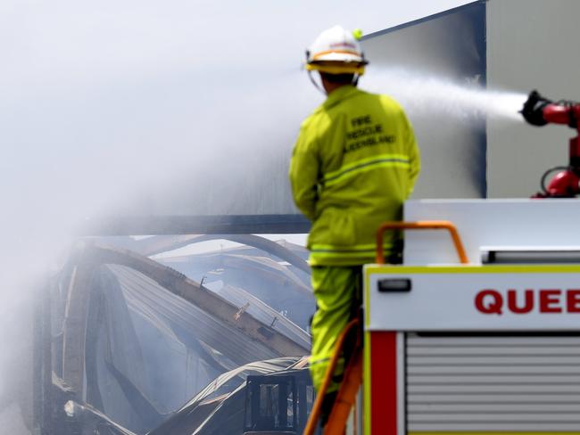 BRISBANE, AUSTRALIA - NewsWire Photos - DECEMBER 17, 2020.A fire truck douses with water the burnt remains of a recycling warehouse which was engulfed by massive blaze yesterday, at Hemmant in Brisbane's east.Picture: NCA NewsWire / Dan Peled