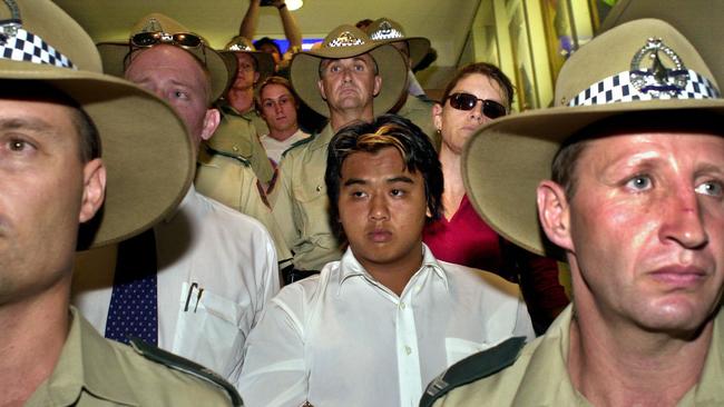 Ben McLean and Phu Ngoc Trinh are escorted by police through Darwin airport