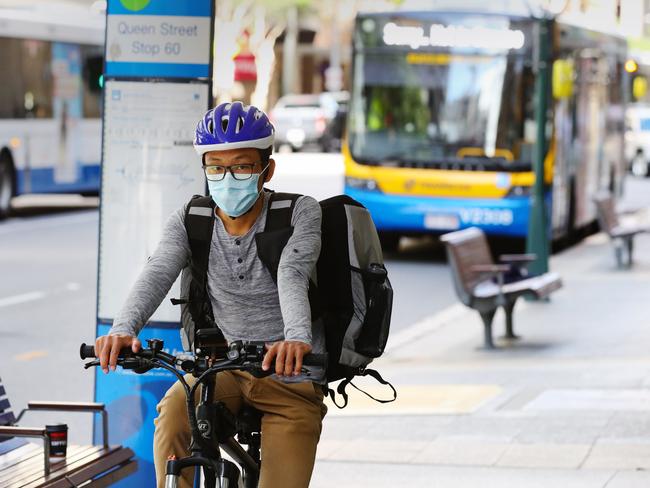 A cyclist wears a face mask for protection from Corona virus in the Brisbane CBD.  Photo Lachie Millard