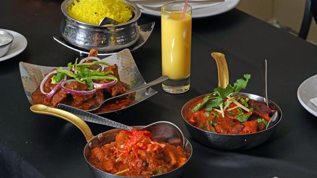 The super spicy Platinum Jubilee Chicken Curry (right) was part of a right Royal spread at the Ashiana Indian Restaurant in Manly, including the goat curry with Padron chillies, the chiken tikka masala and Mango lassi. Picture: Max Agency