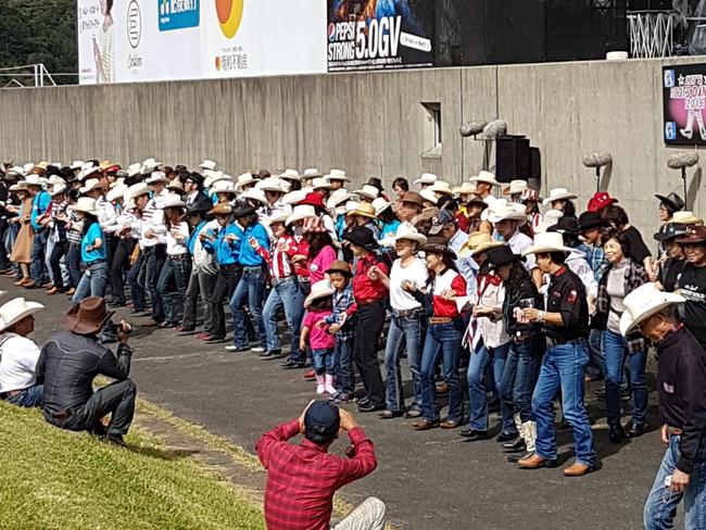 Line dancers get some practice in before the show starts at the Country Gold country music festival at Mt Aso in Japan.