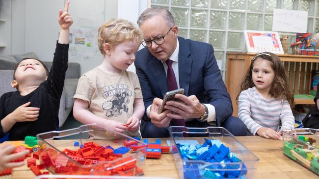 Prime Minister, Anthony Albanese shows Bradley Gosper a picture of his dog, Toto, on his phone while visiting the Manuka Childcare Centre in Canberra. Picture: NCA NewsWire