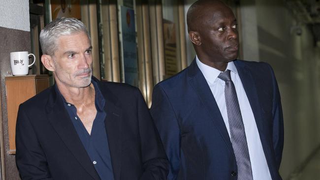 Former Australian soccer captain Craig Foster, left, and vice president of FIFPro Francis Awaritefe wait to meet Hakeem al-Araibi as he arrives at the criminal court in Bangkok on Monday. Picture: AP