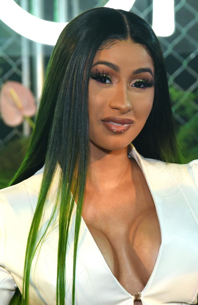 Cardi B shows off the results of her new boob job in very low cut white  suit for her fashion launch