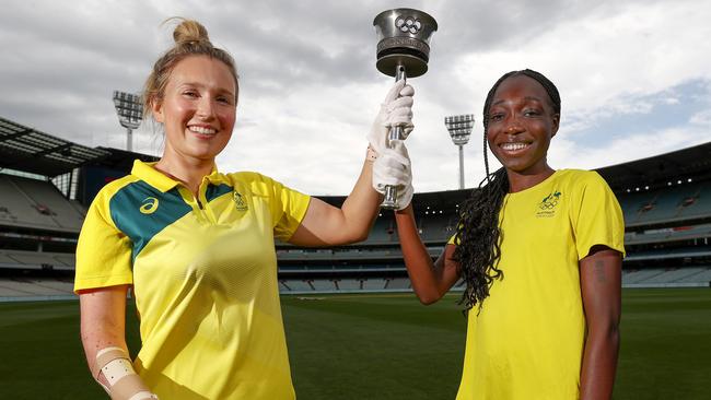 MELBOURNE.  18/11/2021. 65th anniversary of the 1956 olympics at the MCG. Current Olympians Milly Tapper (table tennis) and Bendere Oboya (athletics) with the 1956 Olympic Torch  ...  Photo by Michael Klein.