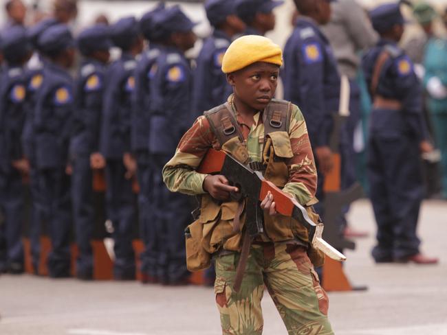 Zimbabwe was the last country to default on their debt to the IMF, and life there is still tough. Here, a young boy dressed as a soldier stands guard while holding a wooden gun during the opening of the 23rd session of the Junior Parliament of Zimbabwe in Harare.