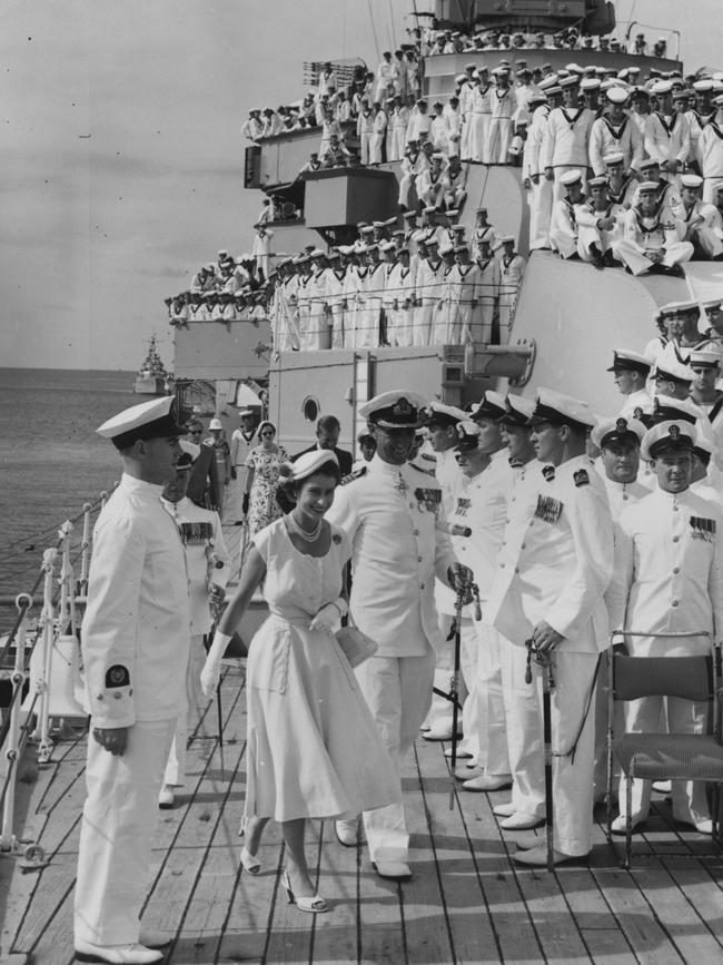 The Queen and Prince Philip visited Australia in 1954 as part of an ambitious Commonwealth tour that began the previous year, and are pictured on <i>HMAS Australia</i> at sea off Townsville. Biographer A N Wilson wrote “there were occasions when the Queen was going through the motions” and describes how the Duke of Edinburgh tried to keep up her spirits as she scowled through the heat in Australia, urging her to: “Cheer up, sausage, it’s not so bad as all that.” Picture: Getty