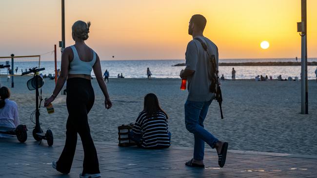 A man, part of Israel's security services, walks along Tel Aviv boardwalk with an assault riffle. Picture: Getty