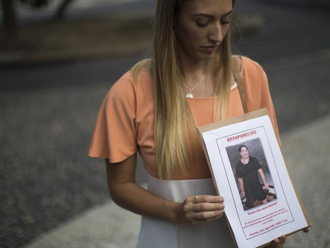 Bonnie Cuthbert shows a photo of her missing boyfriend Rye Hunt, 25, during a press conference in Rio de Janeiro.