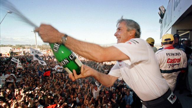 Racing driver Peter Brock spraying champagne over crowd after the final race of his career at Bathurst