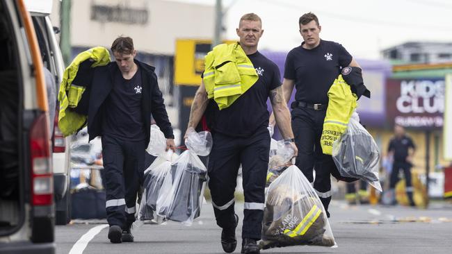 Firefighters remove items from the scene of the fierce blaze. Picture: Matthew Poon