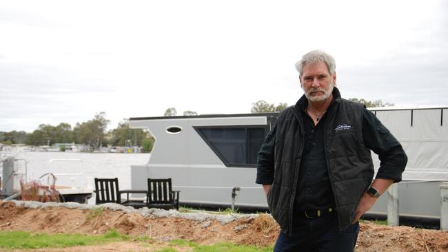 Mannum riverfront home owner Mick Ewens in front of his houseboat.