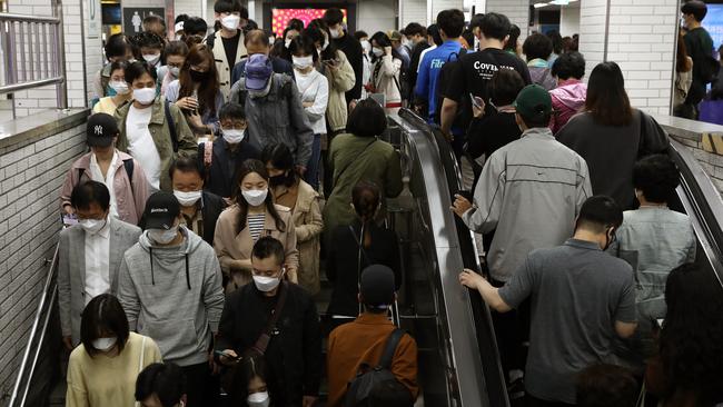 South Korean commuters crowd on an escalator in the subway during rush hour on Monday. Picture; Getty Images.