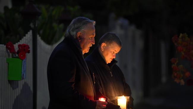 Vietnam veteran Rod Coote (left) and wife Julie watch a live stream of Anzac Day's dawn service outside their house in Melbourne. Picture: AAP