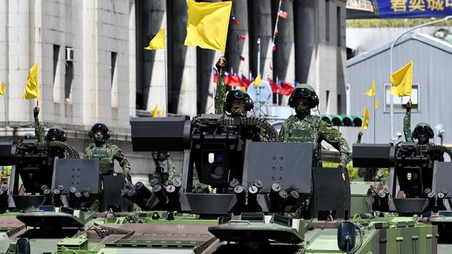 Taiwanese soldiers raise flags on military vehicles during a National Day parade in front of the Presidential Palace during in Taipei on Sunday. Picture: AFP