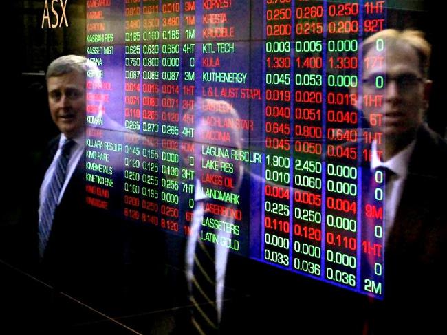 Businessmen stare at the boards of the Australian Stock Exchange (ASX) on Bridge Street, Sydney CBD.