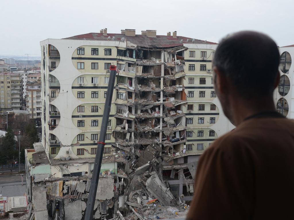 A man looks on at search and rescue operations conducted in the rubble of a collapsed building, in Diyarbakir, Turkey. Picture: AFP