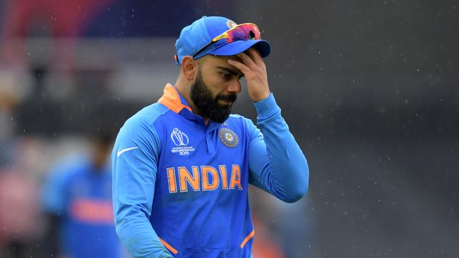 India's captain Virat Kohli walks off the field as rain falls during their semi-final with New Zealand. Picture: AFP