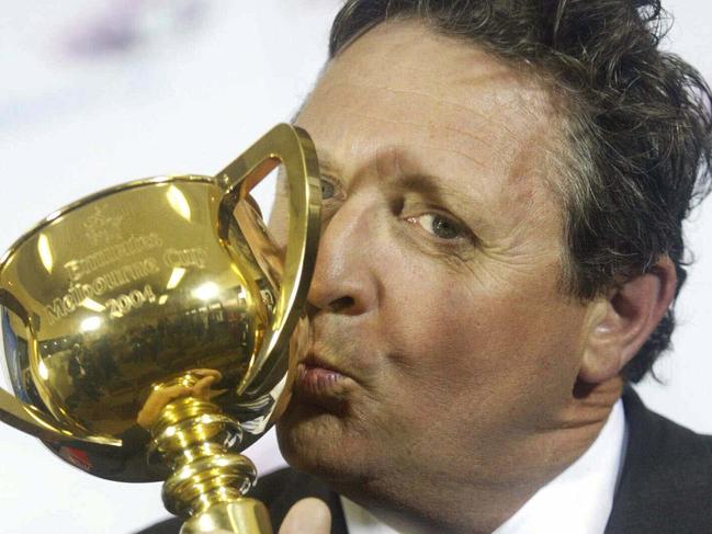 Trainer Lee Freedman kisses Melbourne Cup trophy at Flemington following victory by racehorse Makybe Diva.