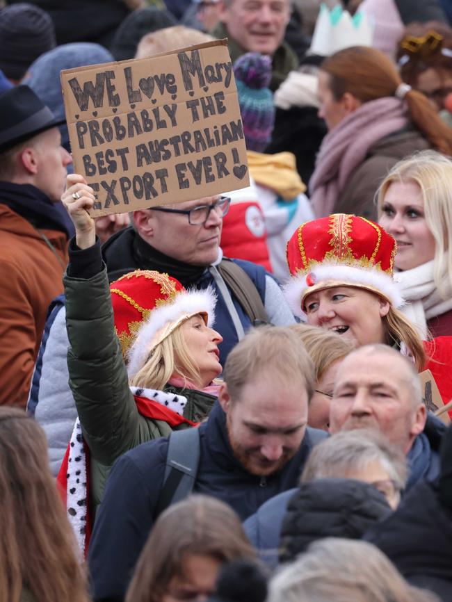 Well-wishers wearing crowns hold a sign reading 'We love Mary. Probably the best Australian export ever!' outside Christiansborg Palace. Picture: Getty Images