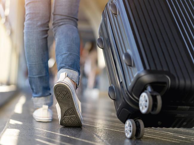 Woman traveler walking alone with suitcase bag. Travel weekend vacation trip.