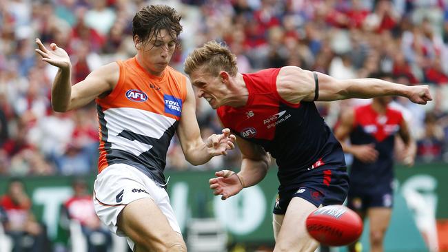 AFL Round 1 — Melbourne v GWS at MCG, GWS Giants Caleb Marchbank gets whacked by Melbourne's Sam Frost after getting his kick away. 26th March 2016. Picture: Colleen Petch.